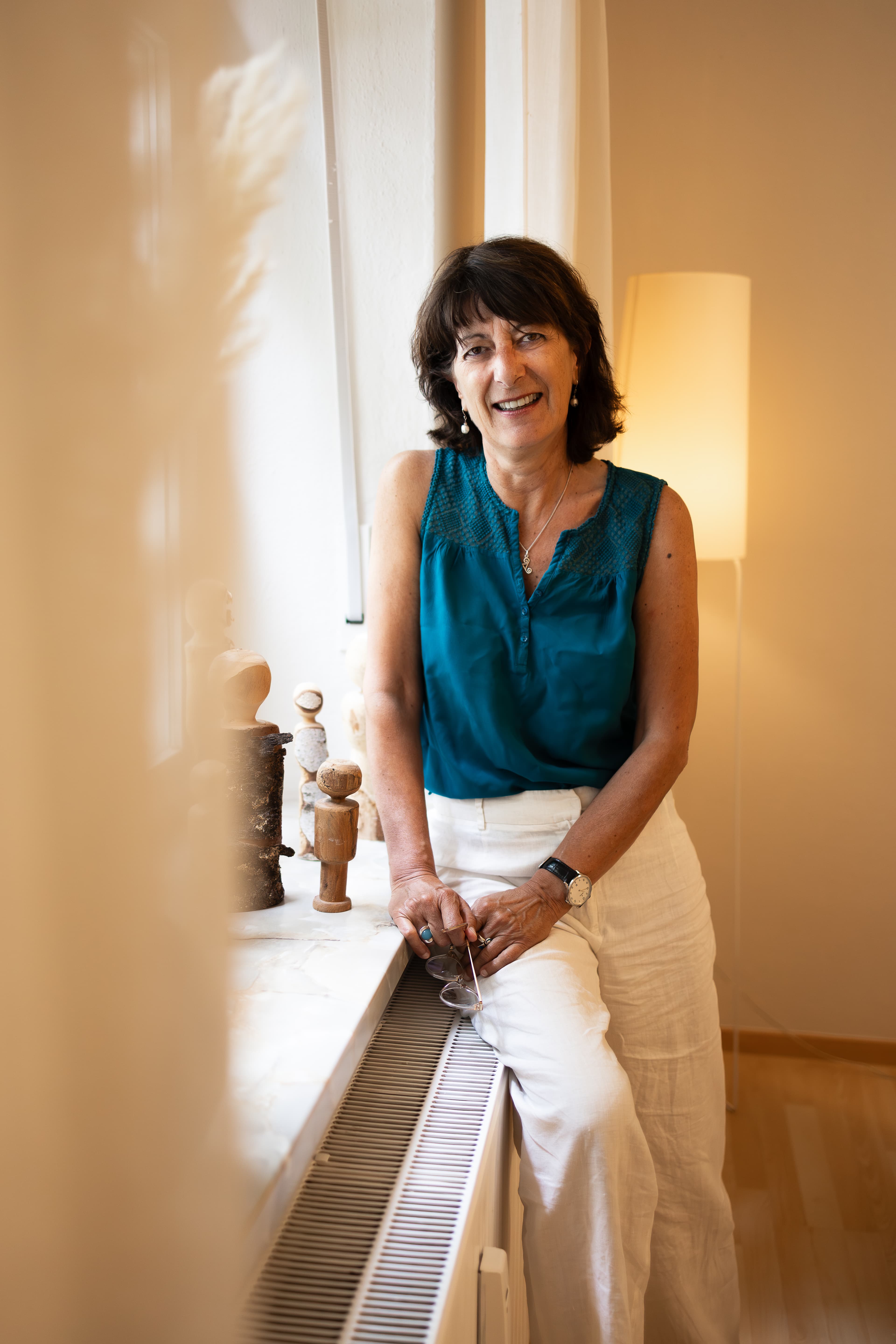 Corinne Charvet in ihrer Praxis in München-Neuhausen, neben Holzfiguren auf der Fensterbank